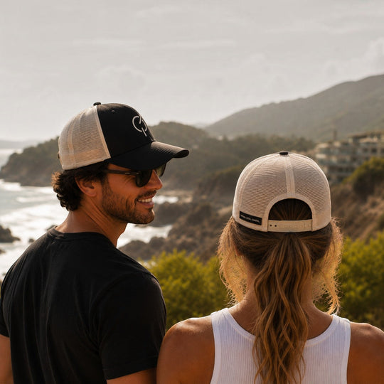 area 609 Core Trucker Hat in black and ecru mesh worn by a man and woman overlooking a coastal landscape